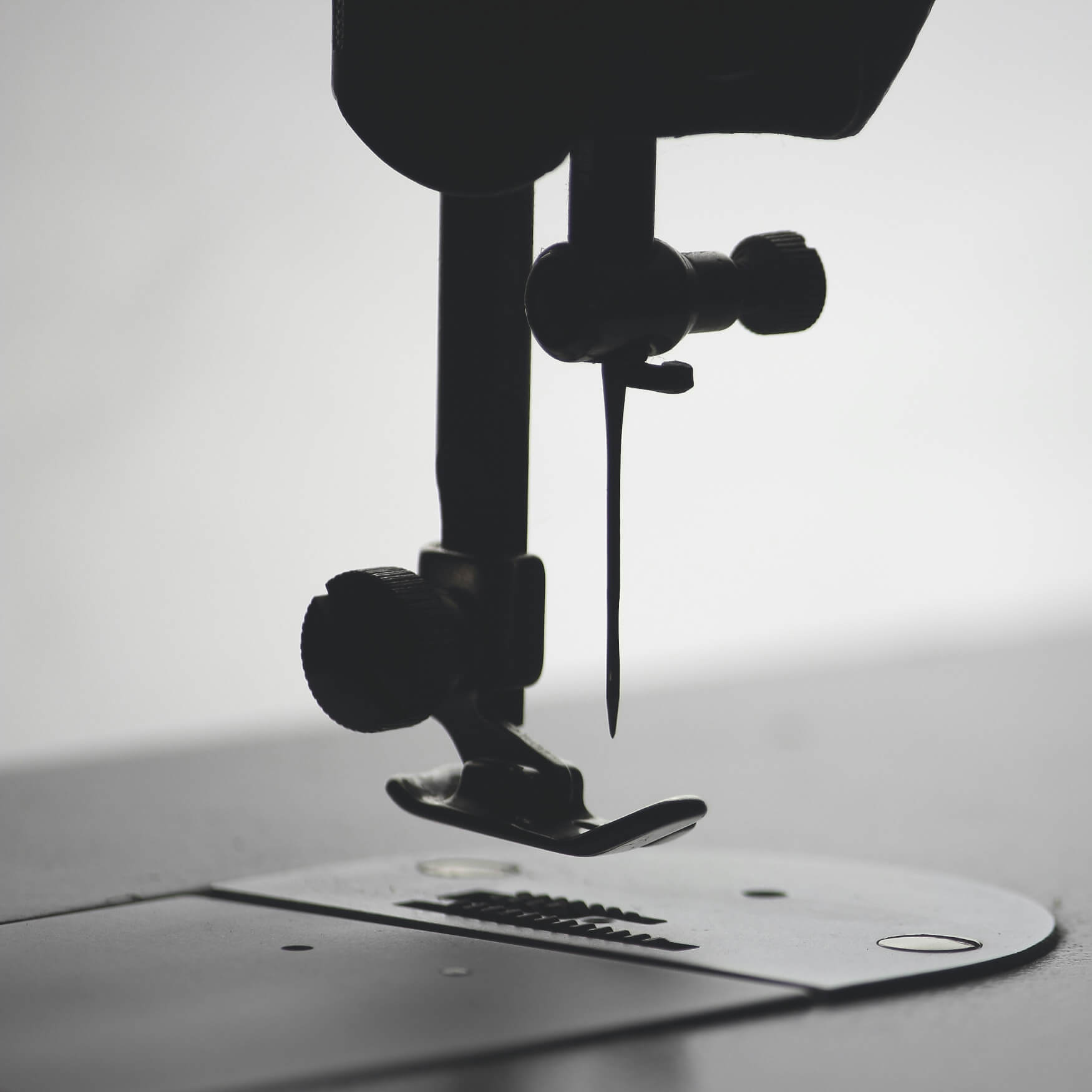 Black and white close-up of a sewing machine needle.